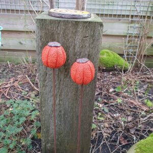 Handgemaakte seedpods van keramiek in de kleur gespikkeld oranje. Bovenop afgewerkt met een koperkleurig dopje. De seedpod is voorzien van een geribbeld oppervlak.