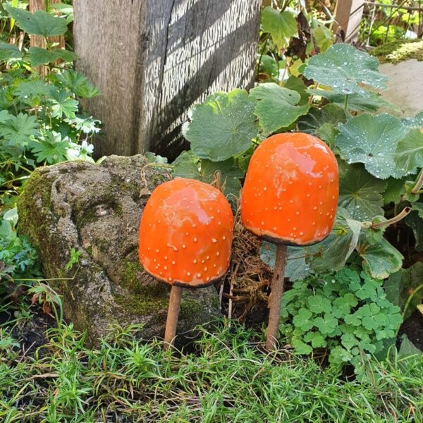 Handgevormde paddenstoelen van keramiek in de mooie kleur oranje met koperen bies aan de onderkant.